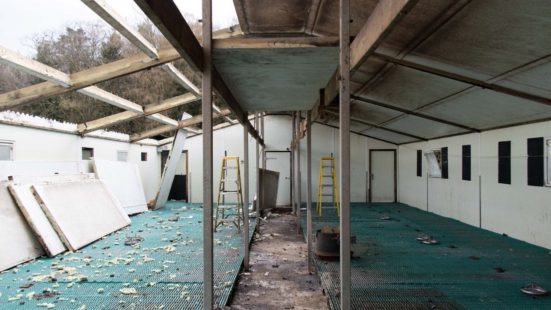 The roof coming off an empty farrowing shed