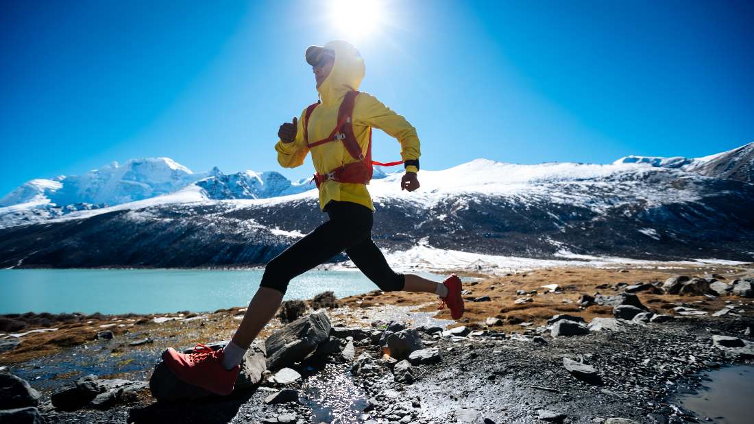 woman running across rocky shore